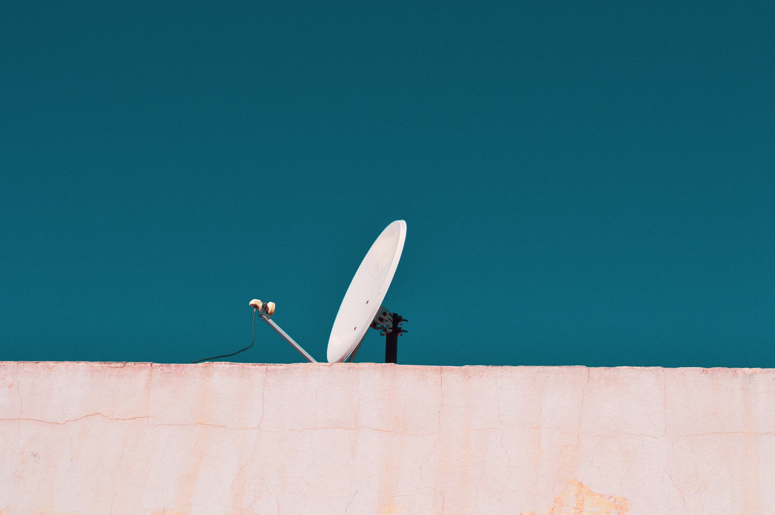 White satellite dish against a blue sky